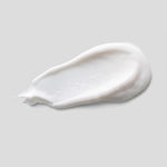 White cream smear on a light gray background