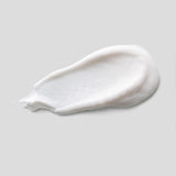 White cream smear on a light gray background