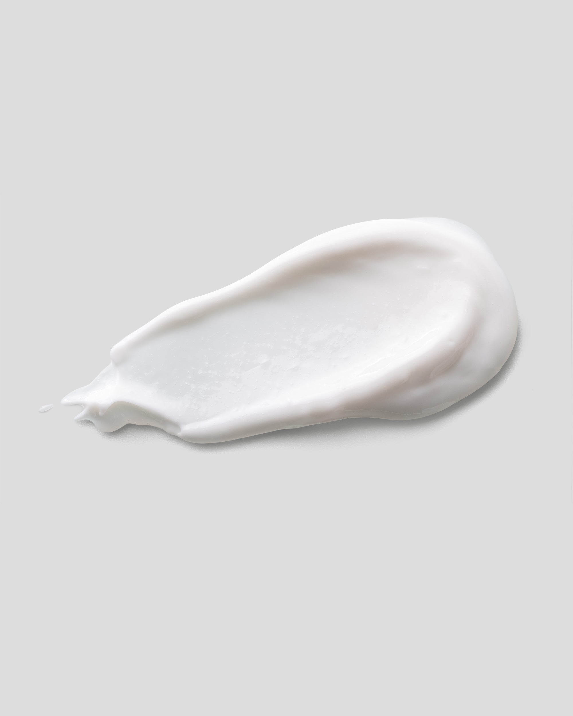 White cream smear on a light gray background